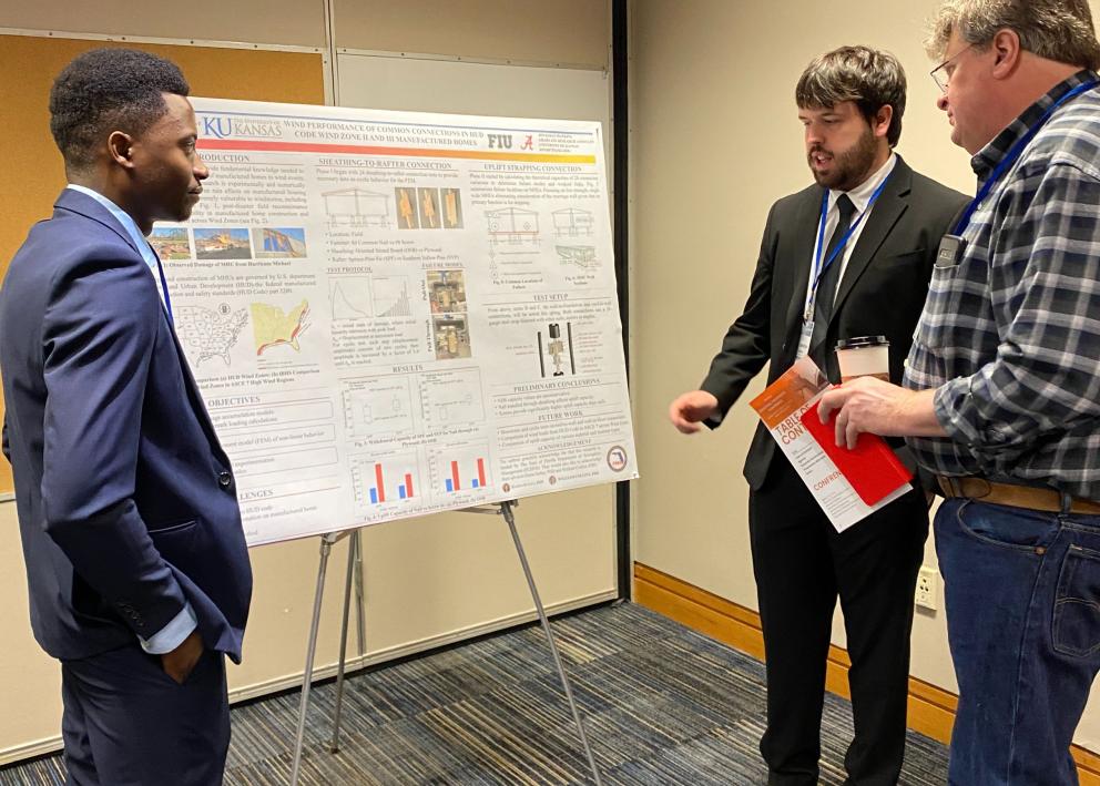 Students presenting research to attendee 