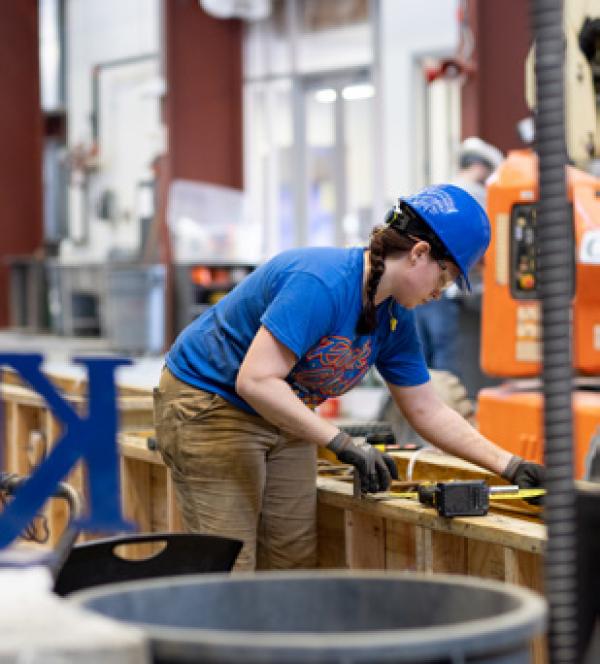 person in a hardhat working with wood